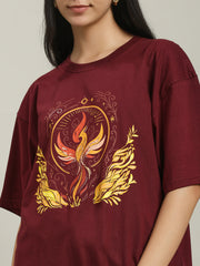Detailed close-up of the Fire women's over-sized T-shirt featuring a vibrant phoenix surrounded by flames and ornate golden leaves, highlighting the intricate design and rich maroon fabric