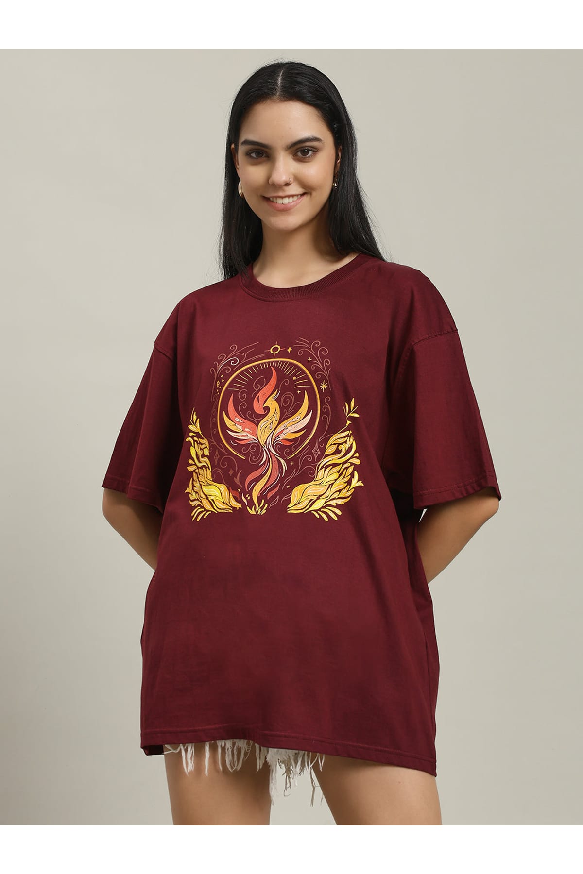 Close-up of a woman wearing a maroon Fire women's over-sized T-shirt with a detailed phoenix and fire graphic on the front, showing the design and fabric texture